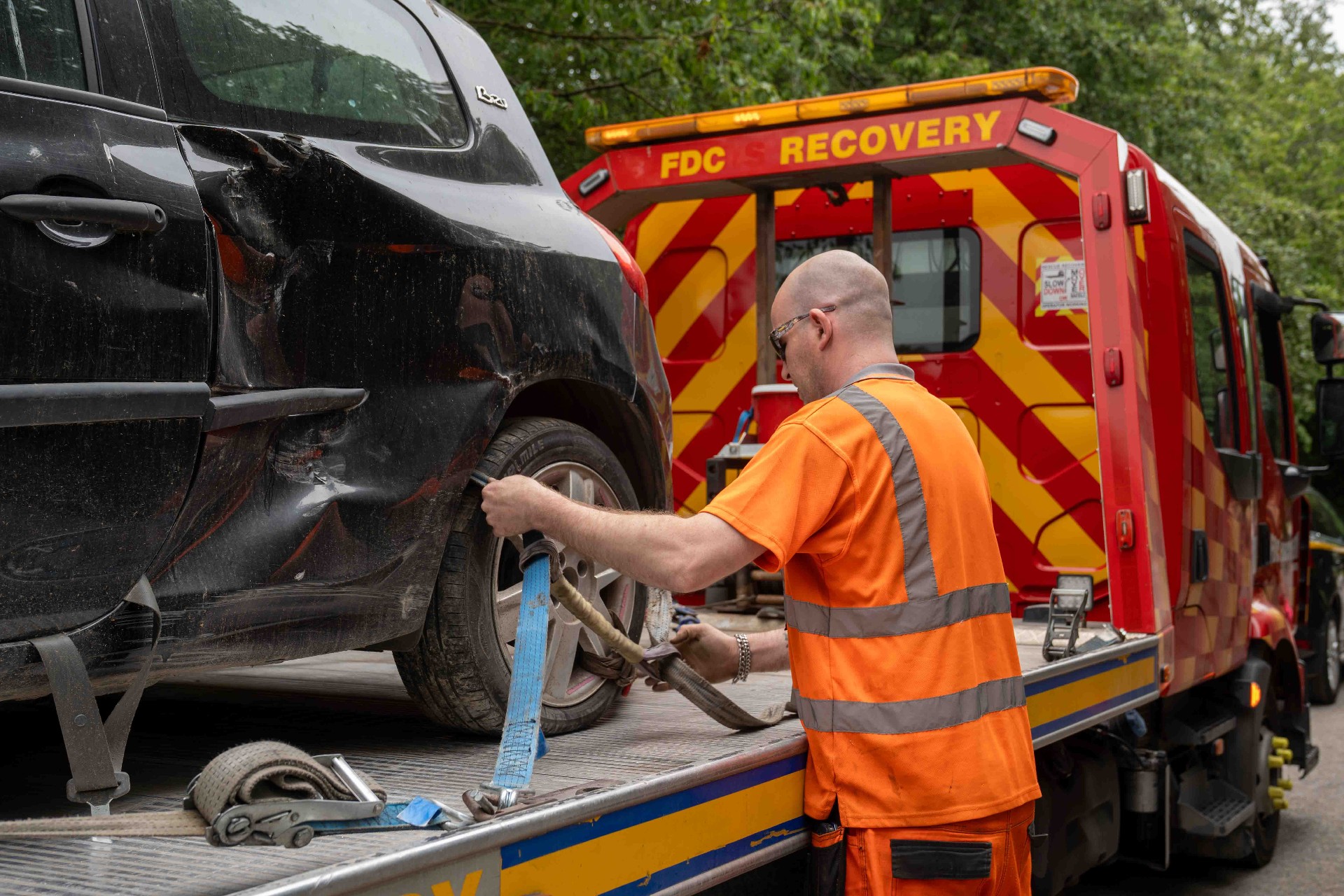 FDC technician strapping a car to the flatbed