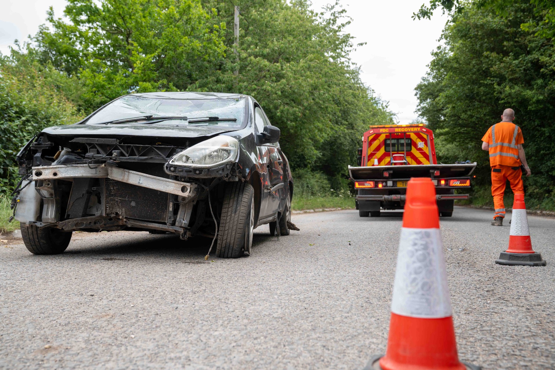 Damaged car being coned off on a country road